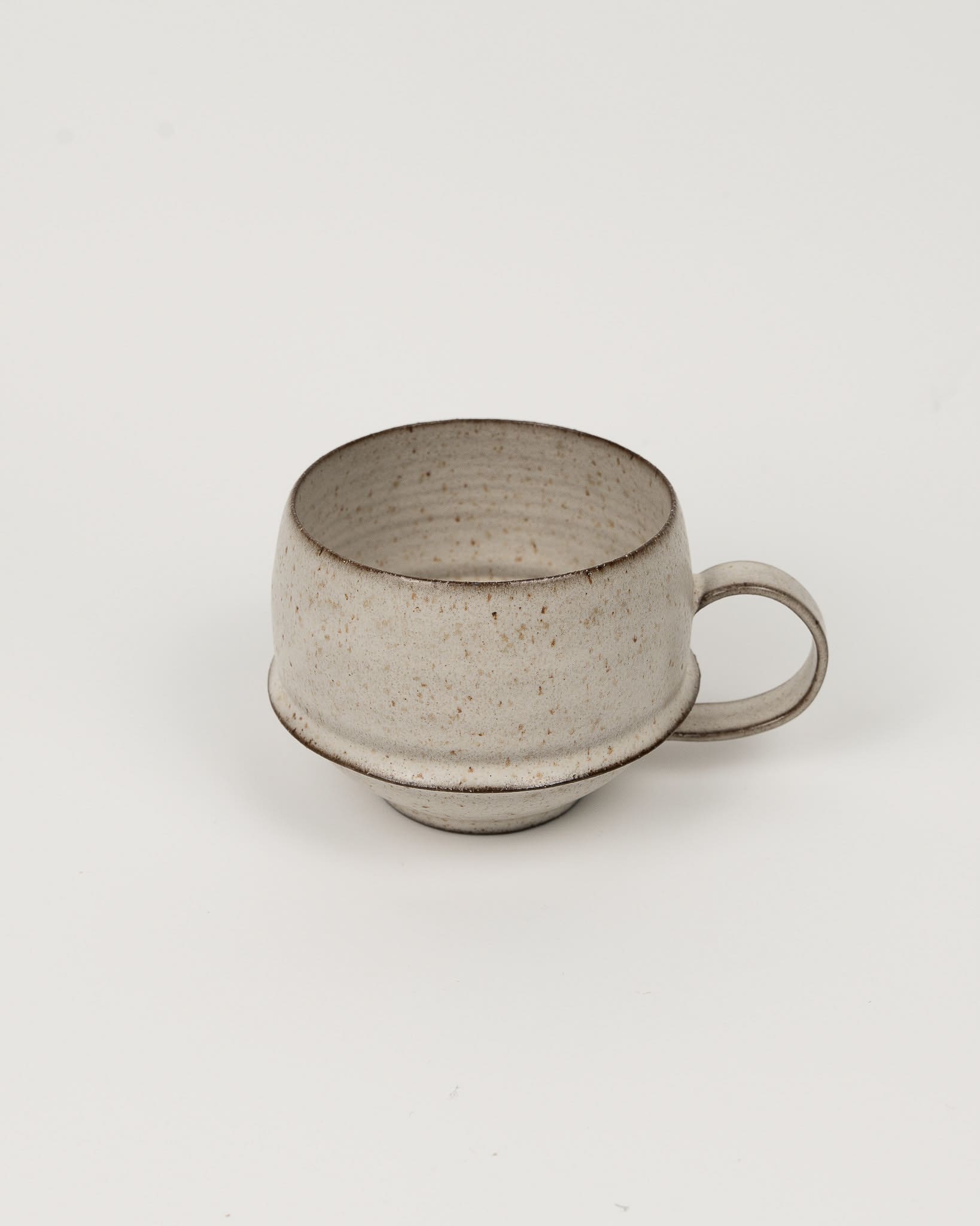 Beige ceramic cup on a light beige background