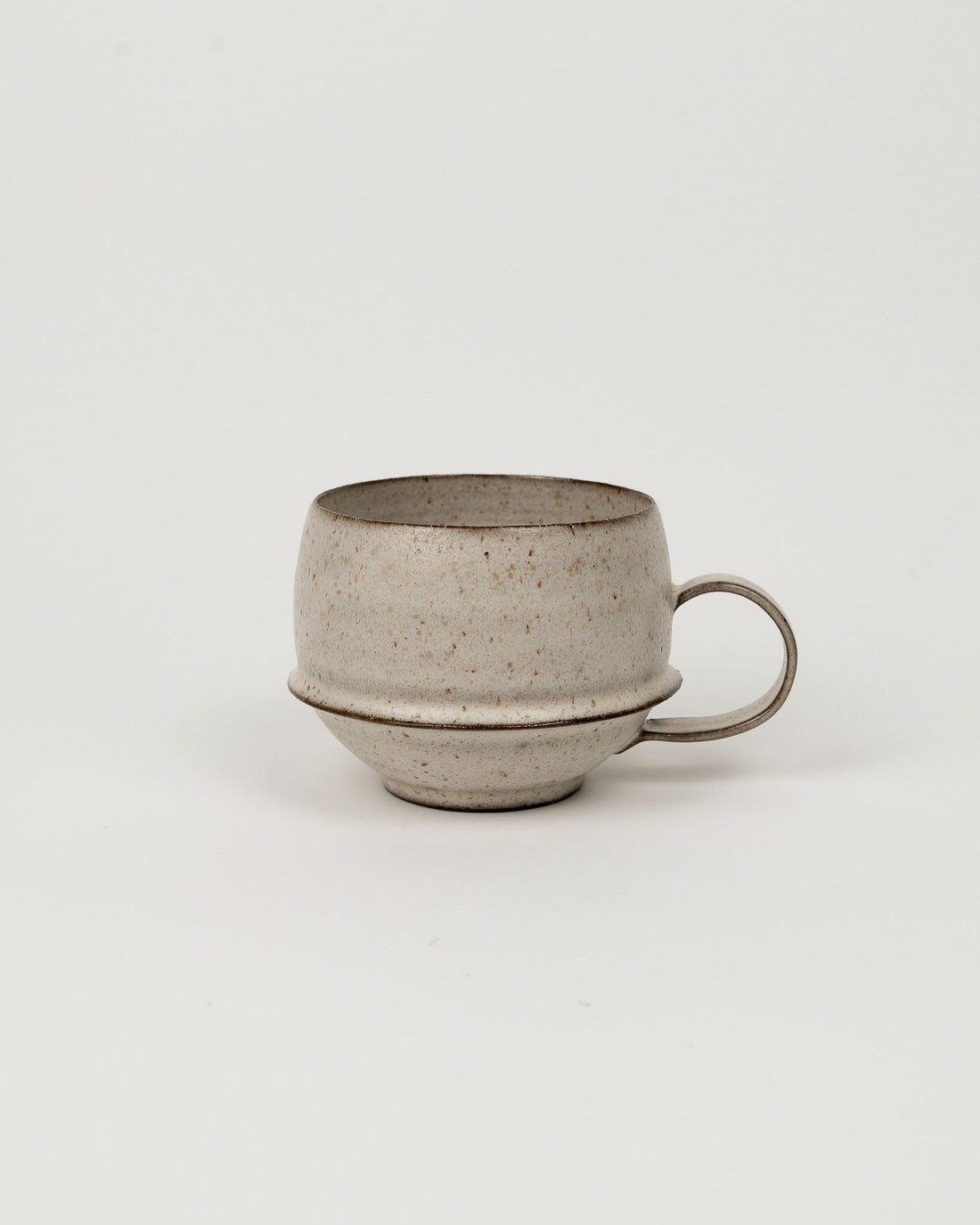 Lunar Sand footed coffee mug with rounded body and loop handle