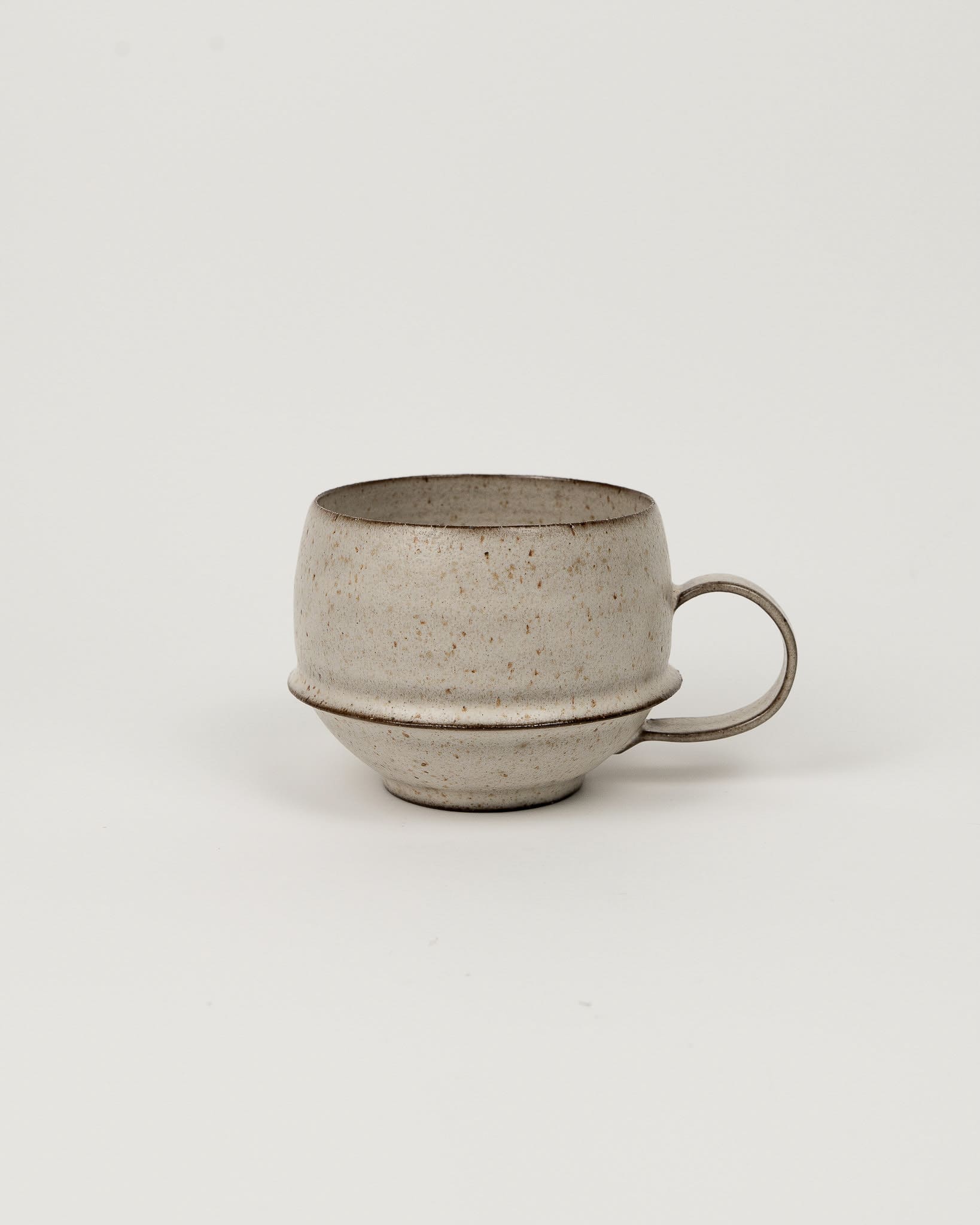 Speckled ceramic mug on a light gray background