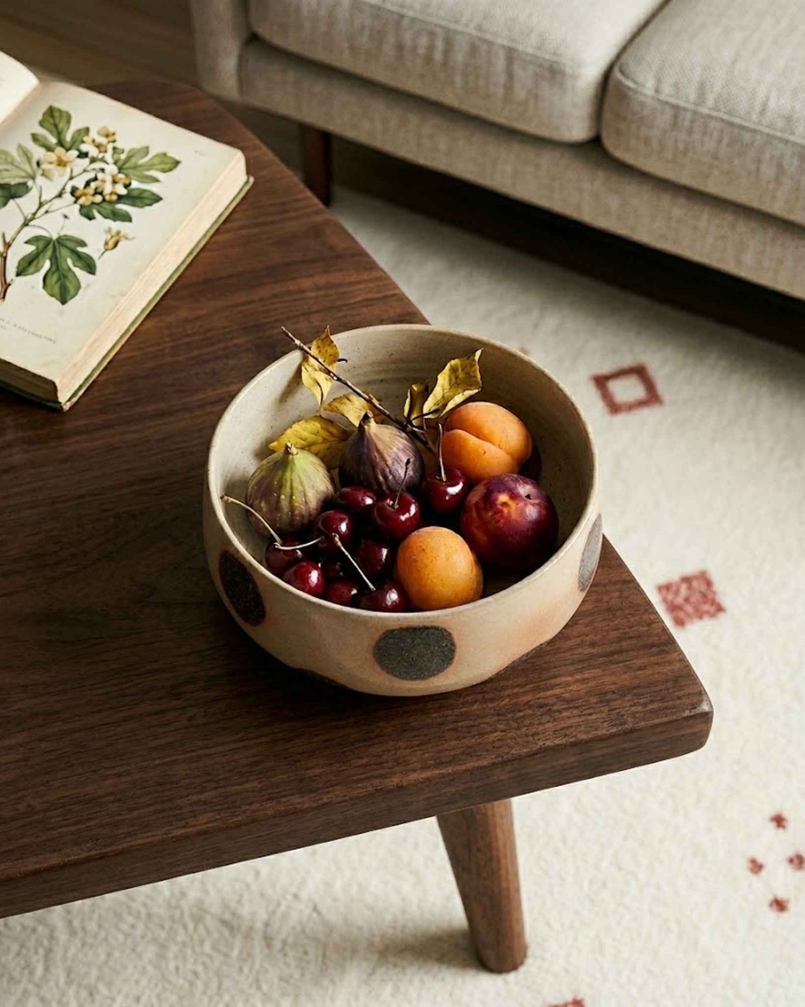 Bowl of fruit on a wooden coffee table with a book in the background