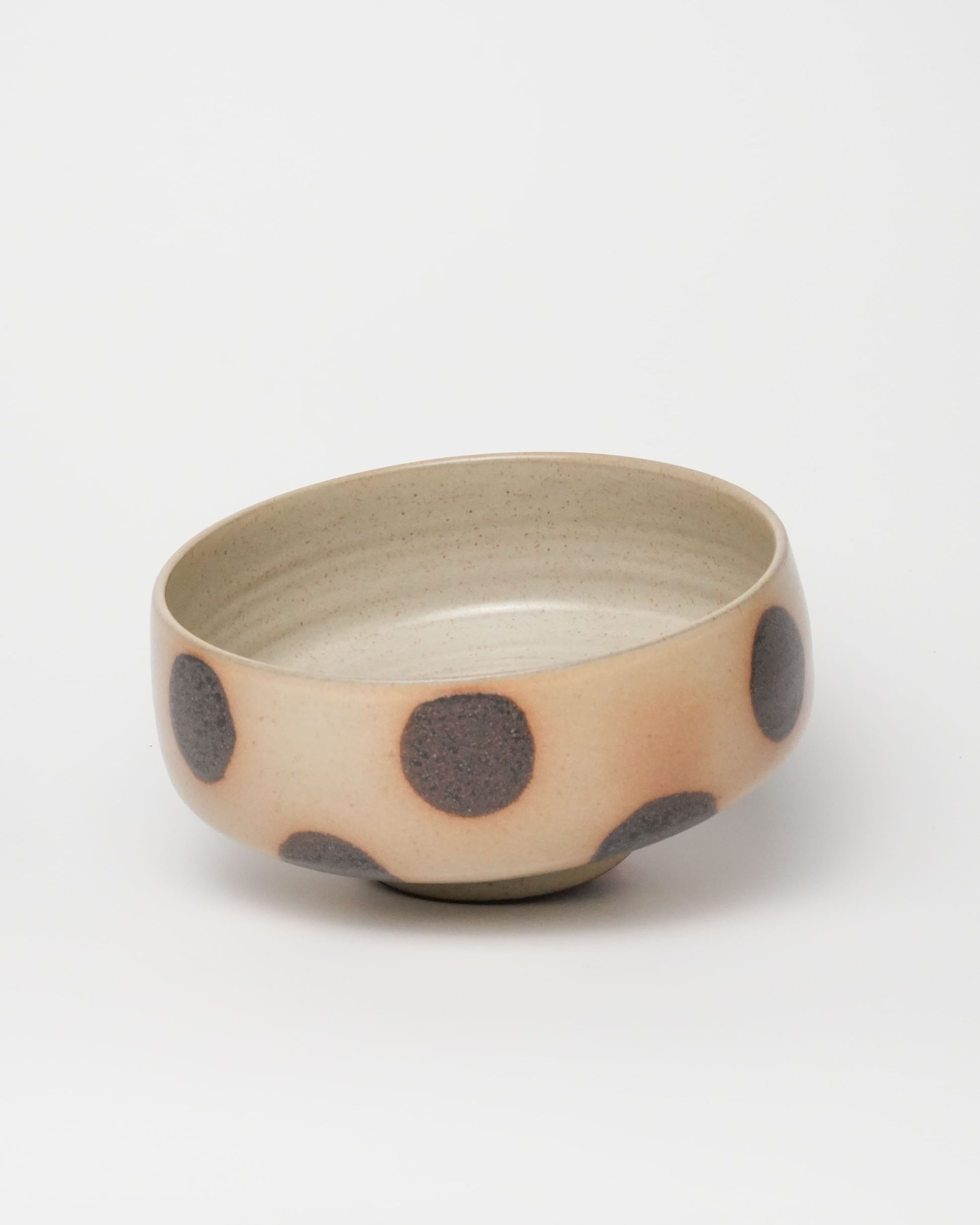 Ceramic bowl with brown polka dots on a white background