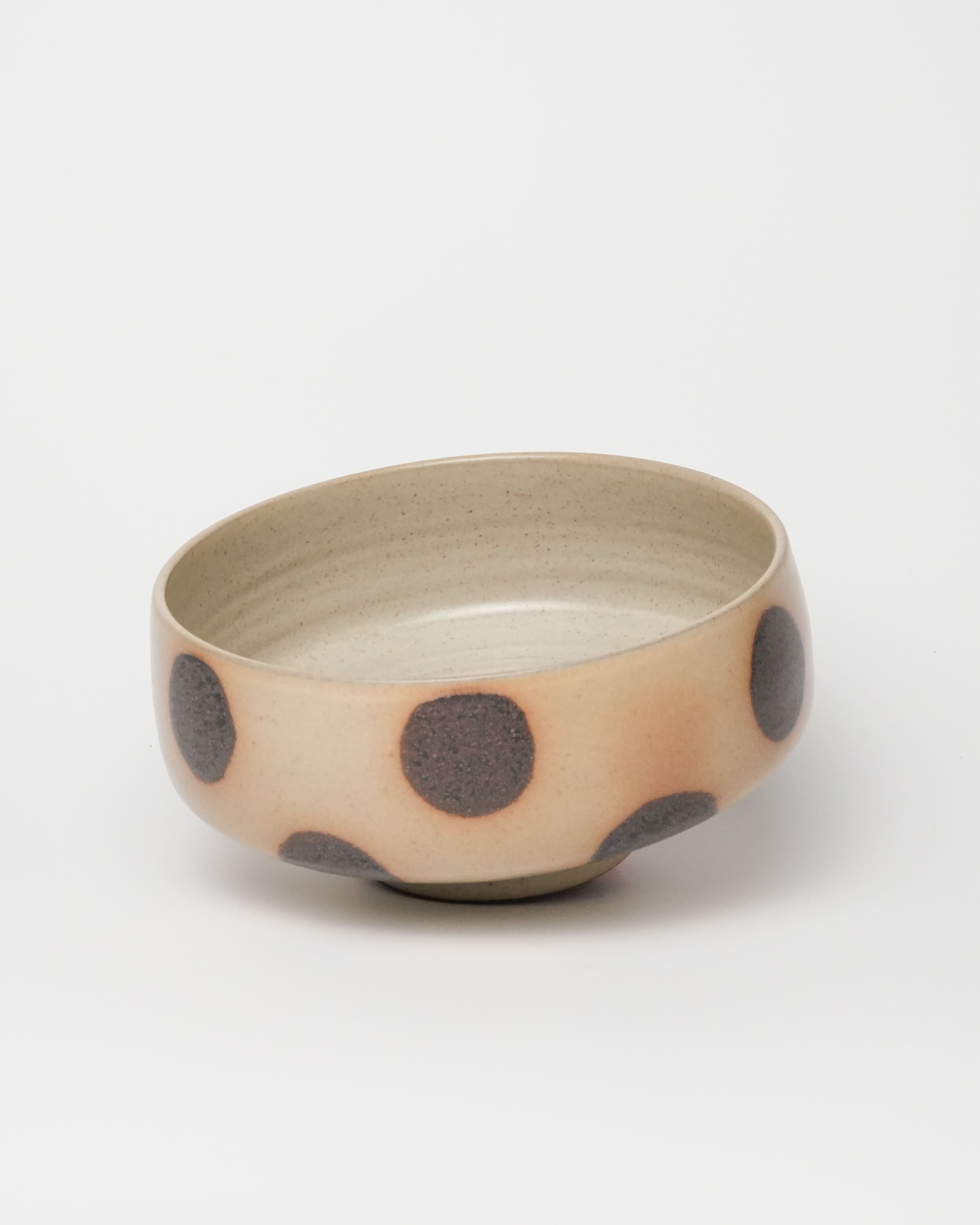 Ceramic bowl with brown polka dots on a white background