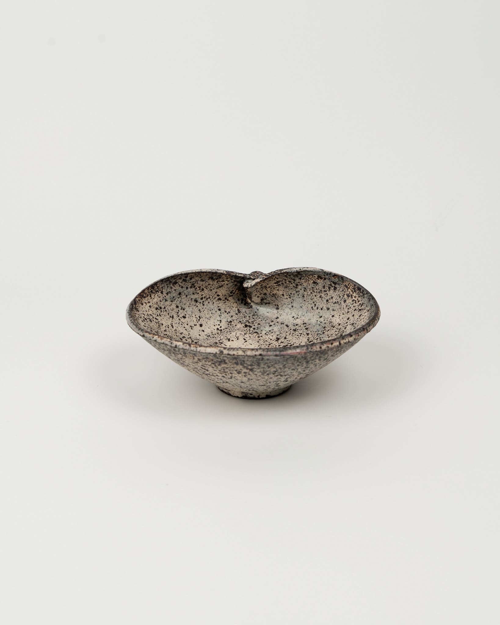 Small ceramic bowl with speckled texture on a white background