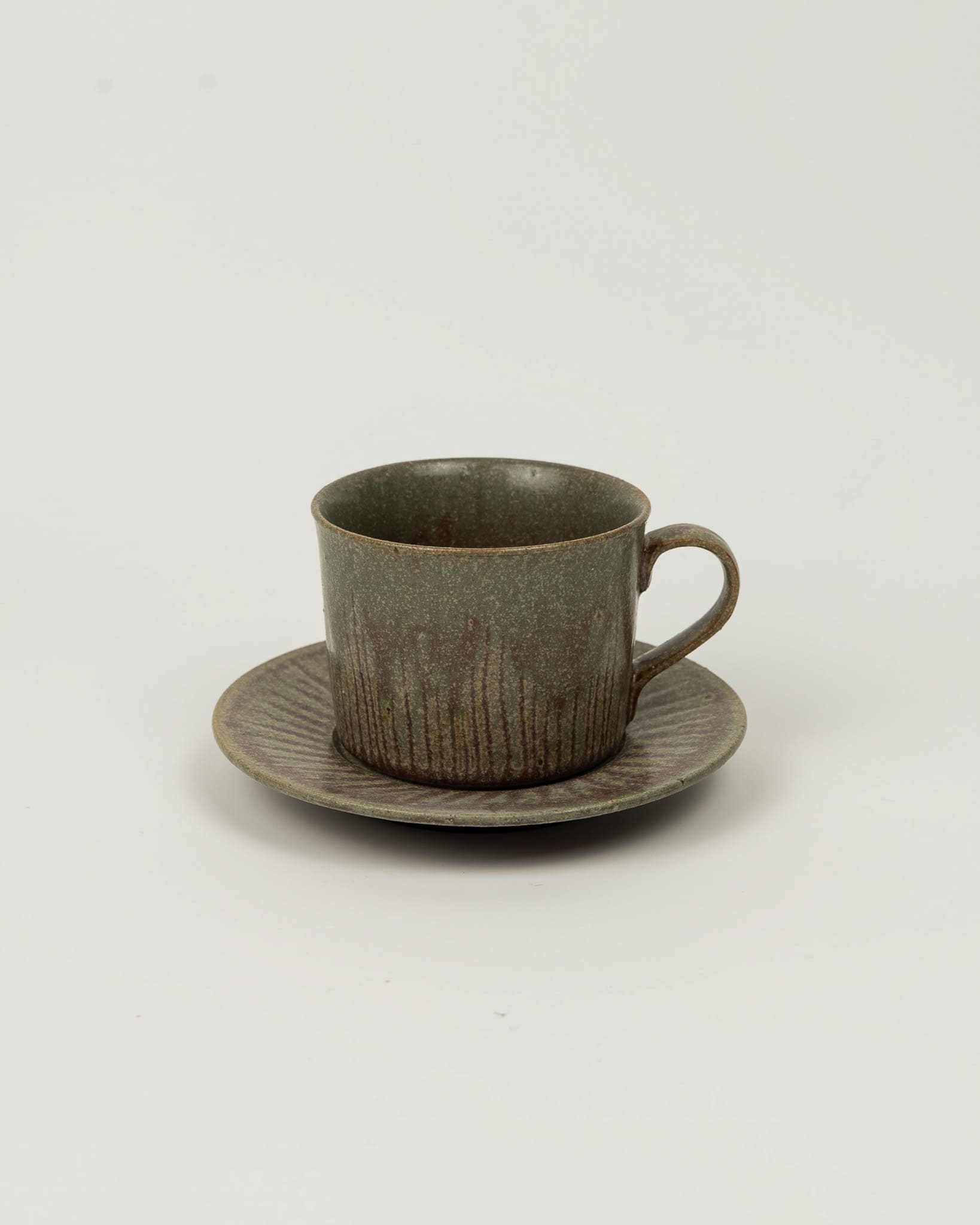 Ceramic cup and saucer set on a light gray background