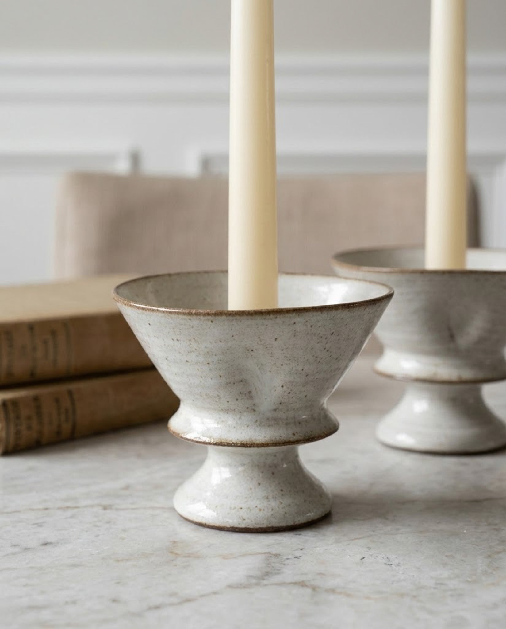 Ceramic candle holders with candles on a marble surface